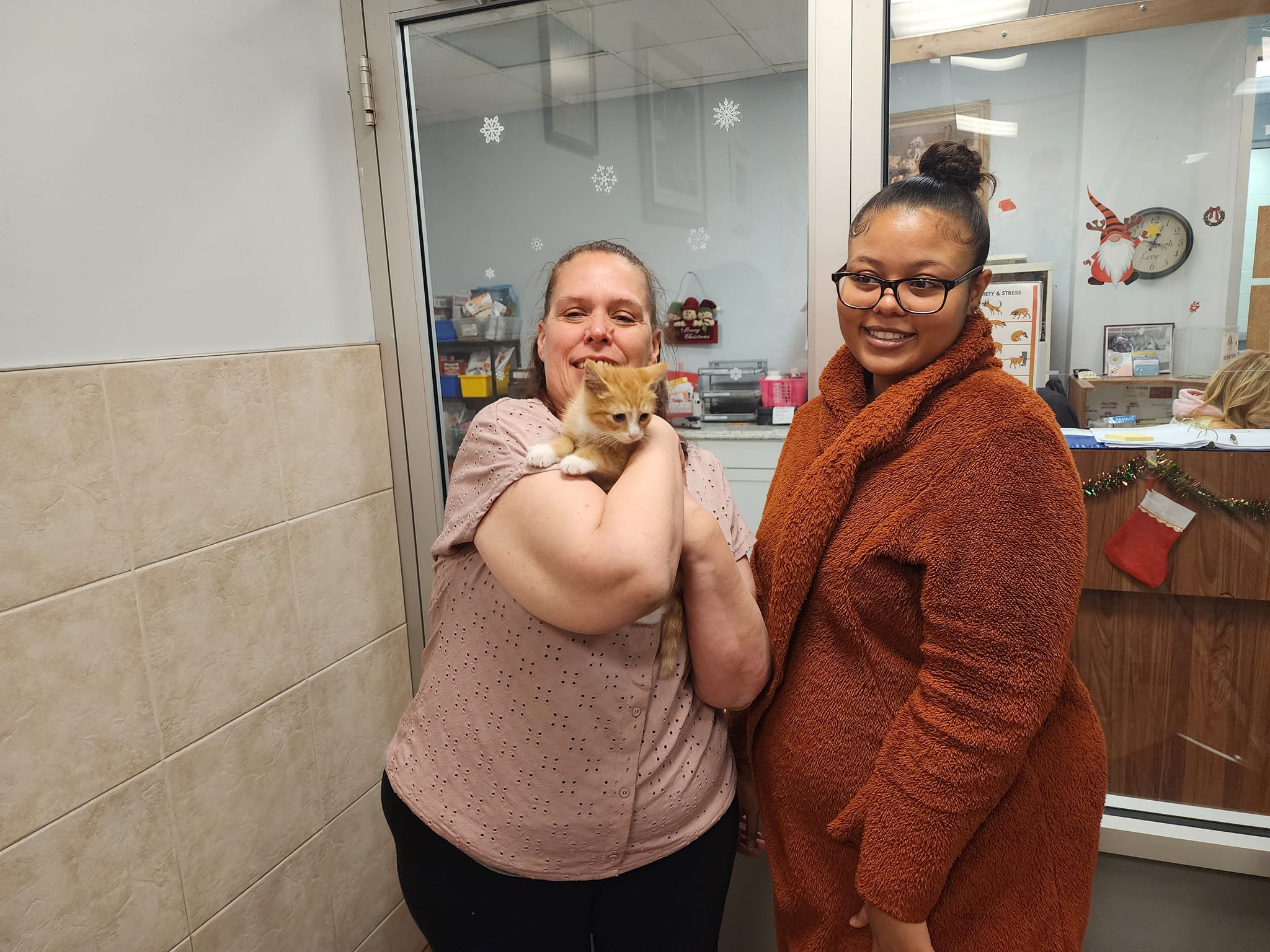 two woman and a kitten