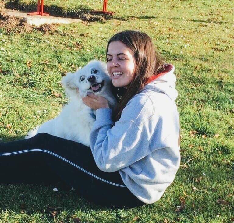 woman and dog sitting on grass