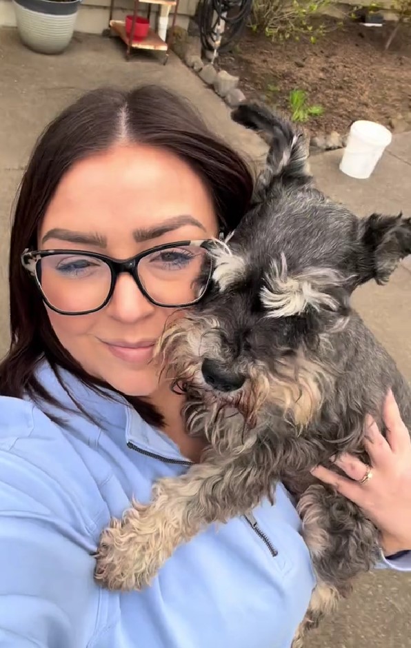 woman holding black dog