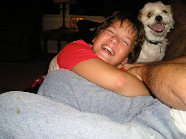 Boy Hugging Small Dog