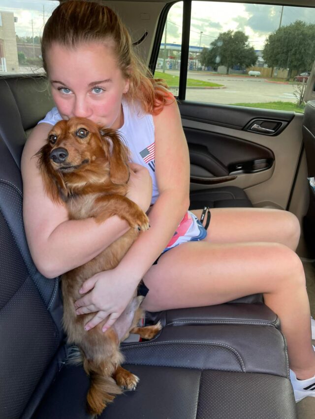 Girl cuddling with Dachshund