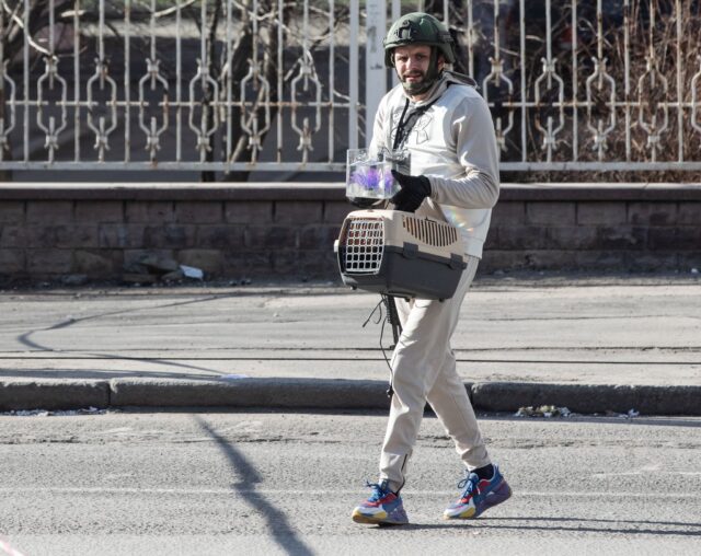 Man with fish tank and cat carrier