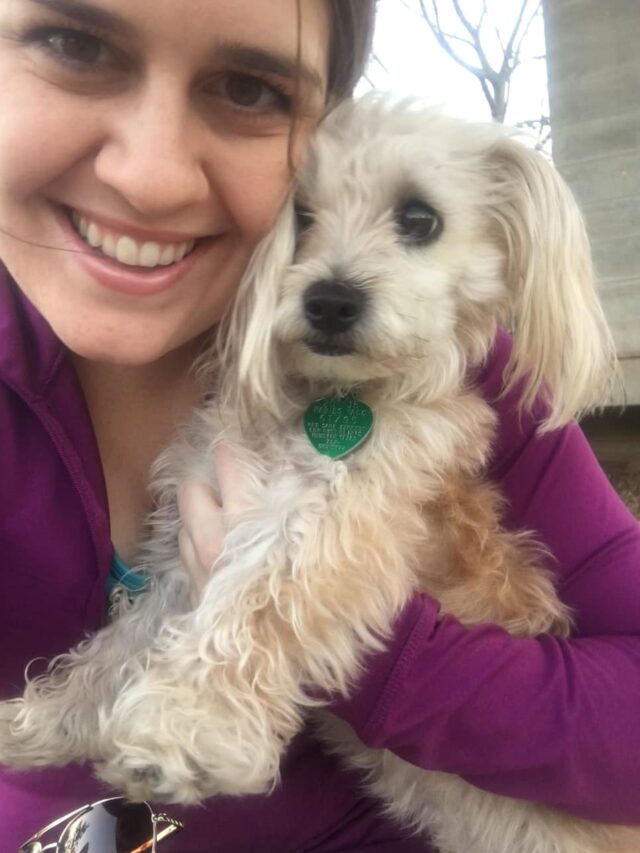 Woman cuddling small dog